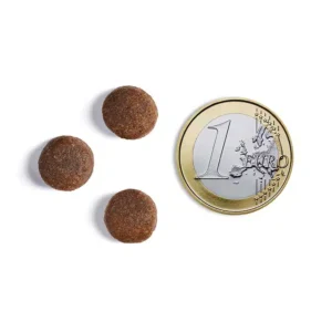 Three pills next to one Euro coin.